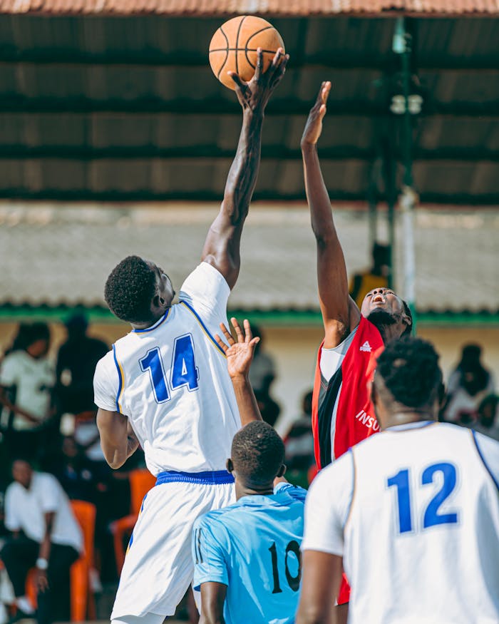 Intense basketball game with players going for a jump shot, showcasing athletic skill and sportsmanship.